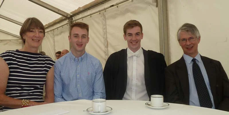 Four people seated at a table in a marquee